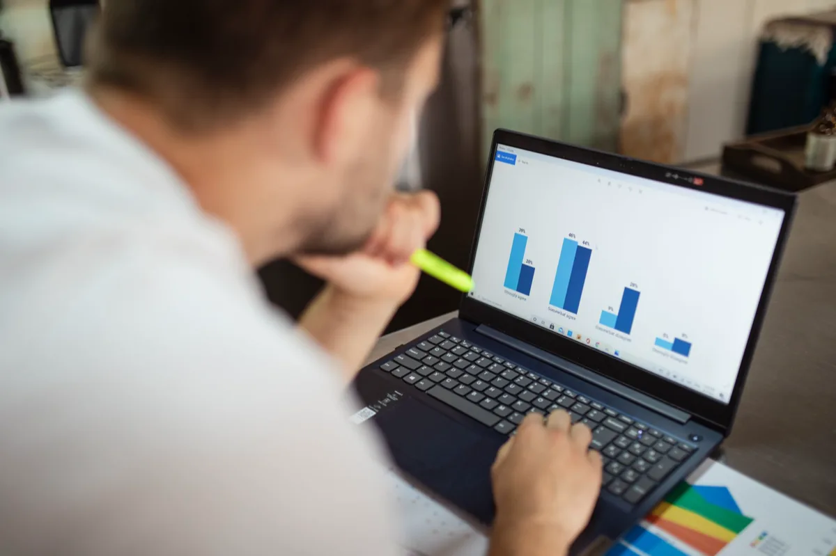 Empresário brasileiro feliz olhando gráficos de crescimento