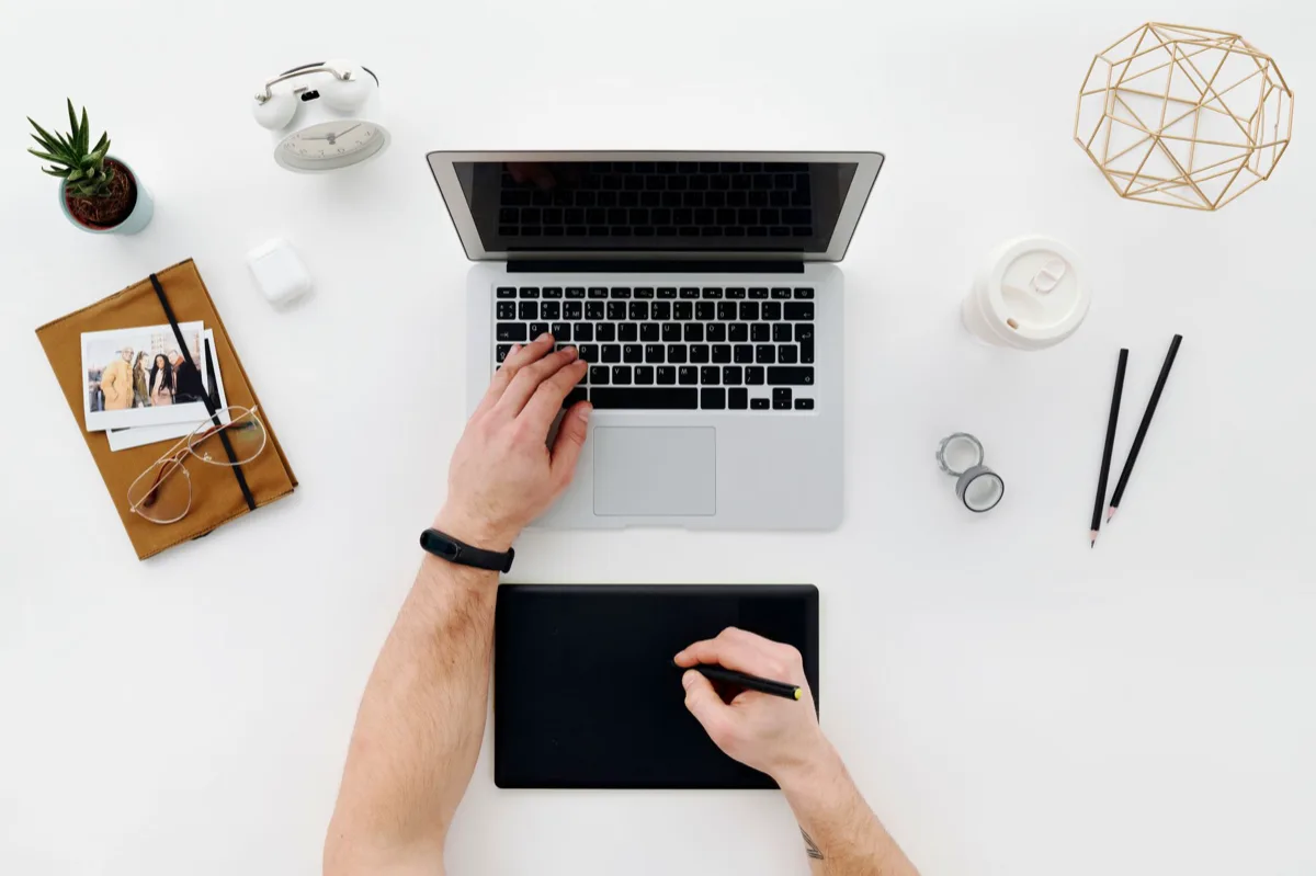 Web designer desenhando wireframes com laptop e café