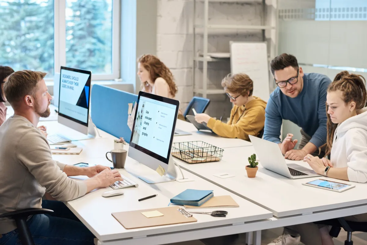 Equipe de funcionários usando computadores e smartphones no escritório