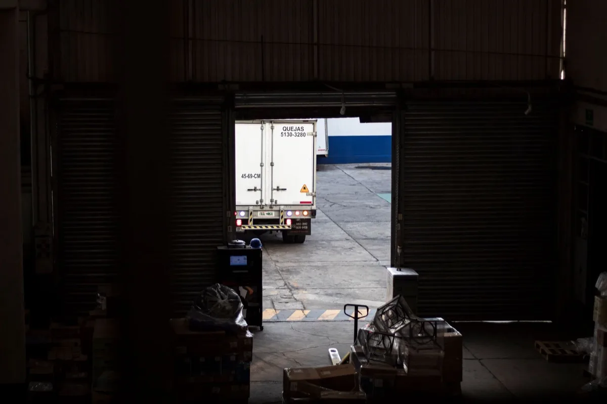 Caminhão de entrega saindo de doca de armazém
